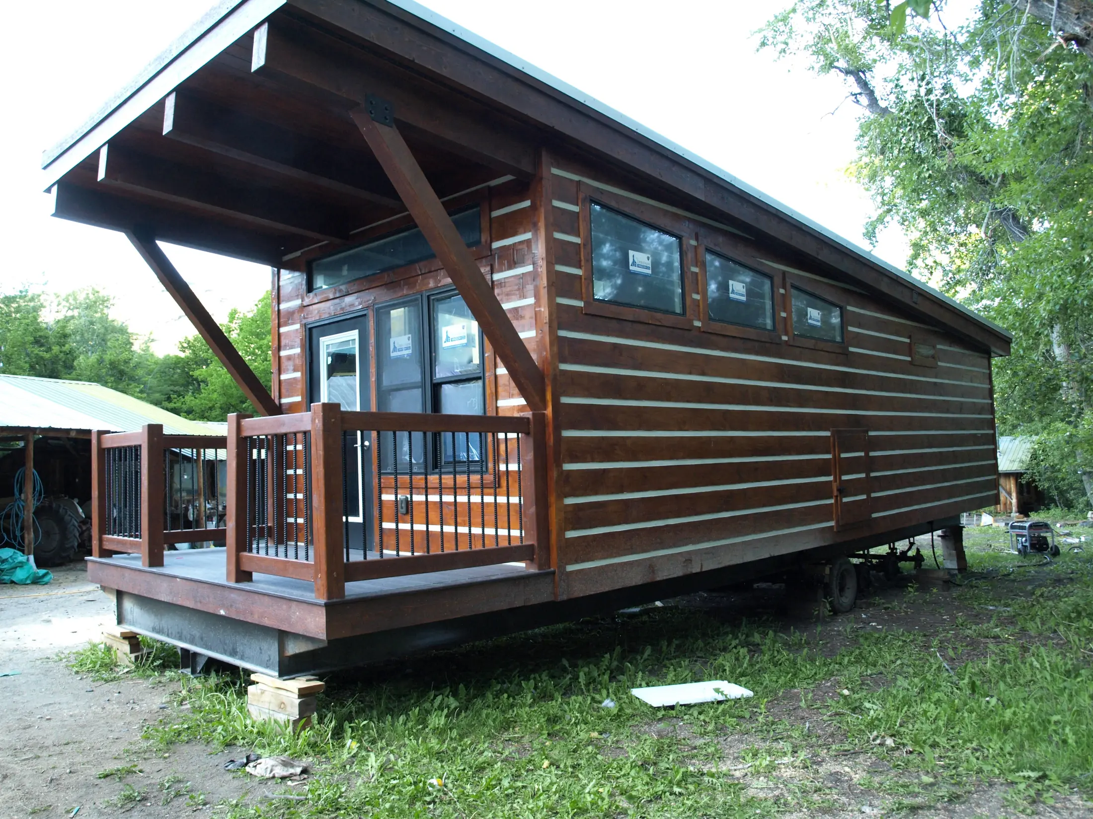 Shed-roof portable cabin with chink-style log siding on its transport frame